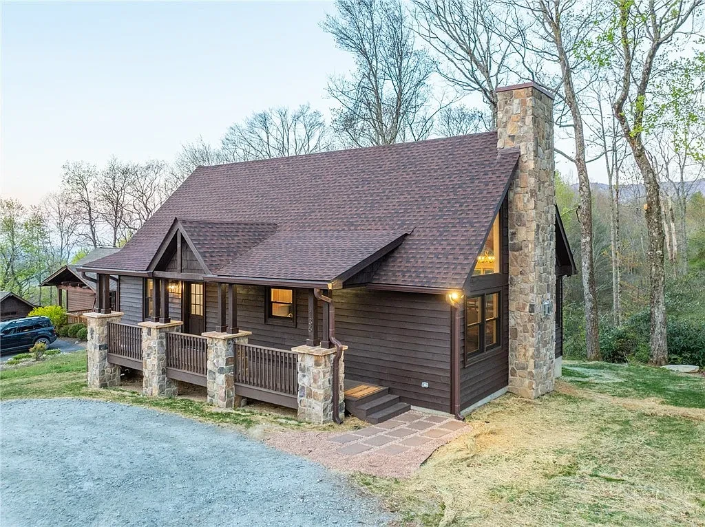 Wood-sided mountain cabin with a covered front porch and stone posts