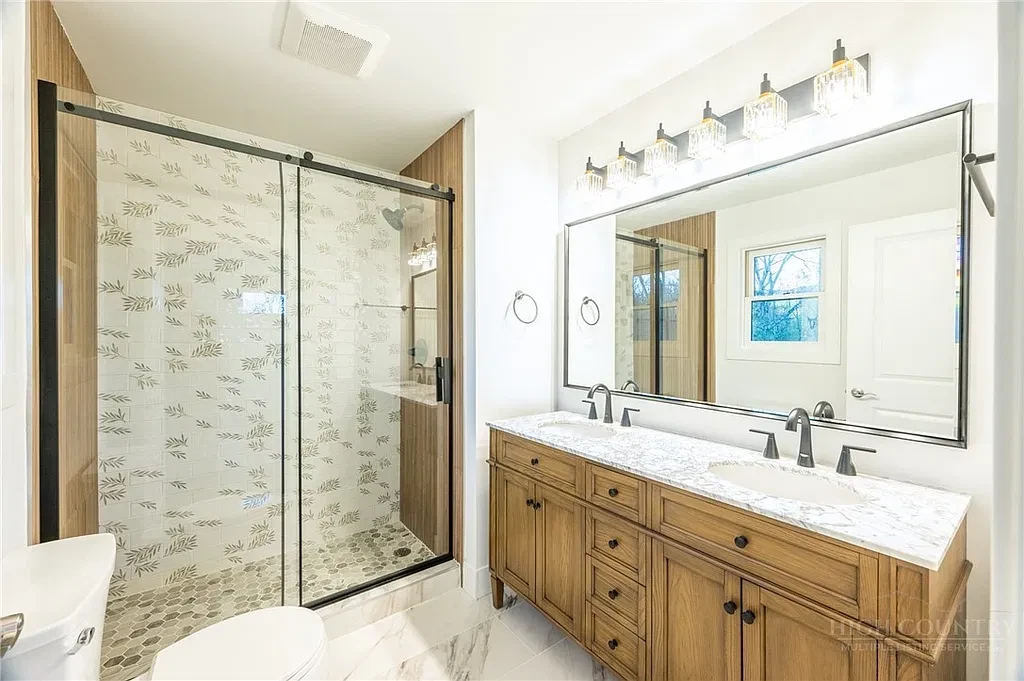 Bright bathroom with a tiled glass shower and timber vanity