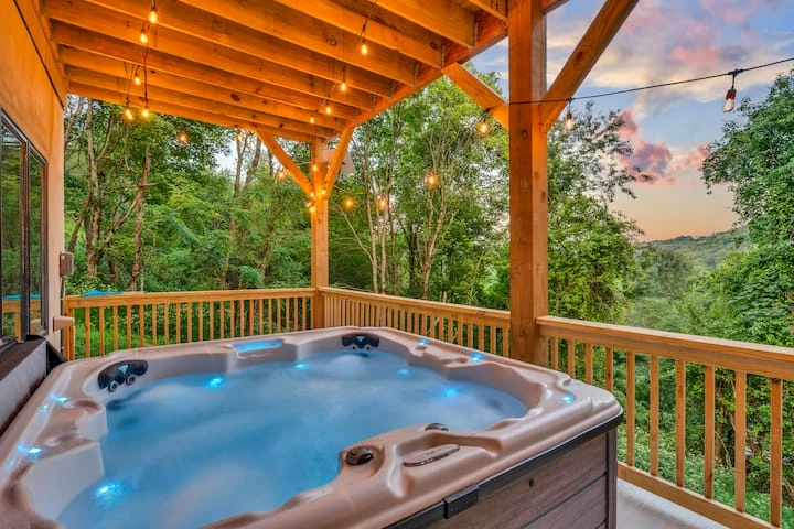 Covered timber deck with railings and a hot tub overlooking the woods