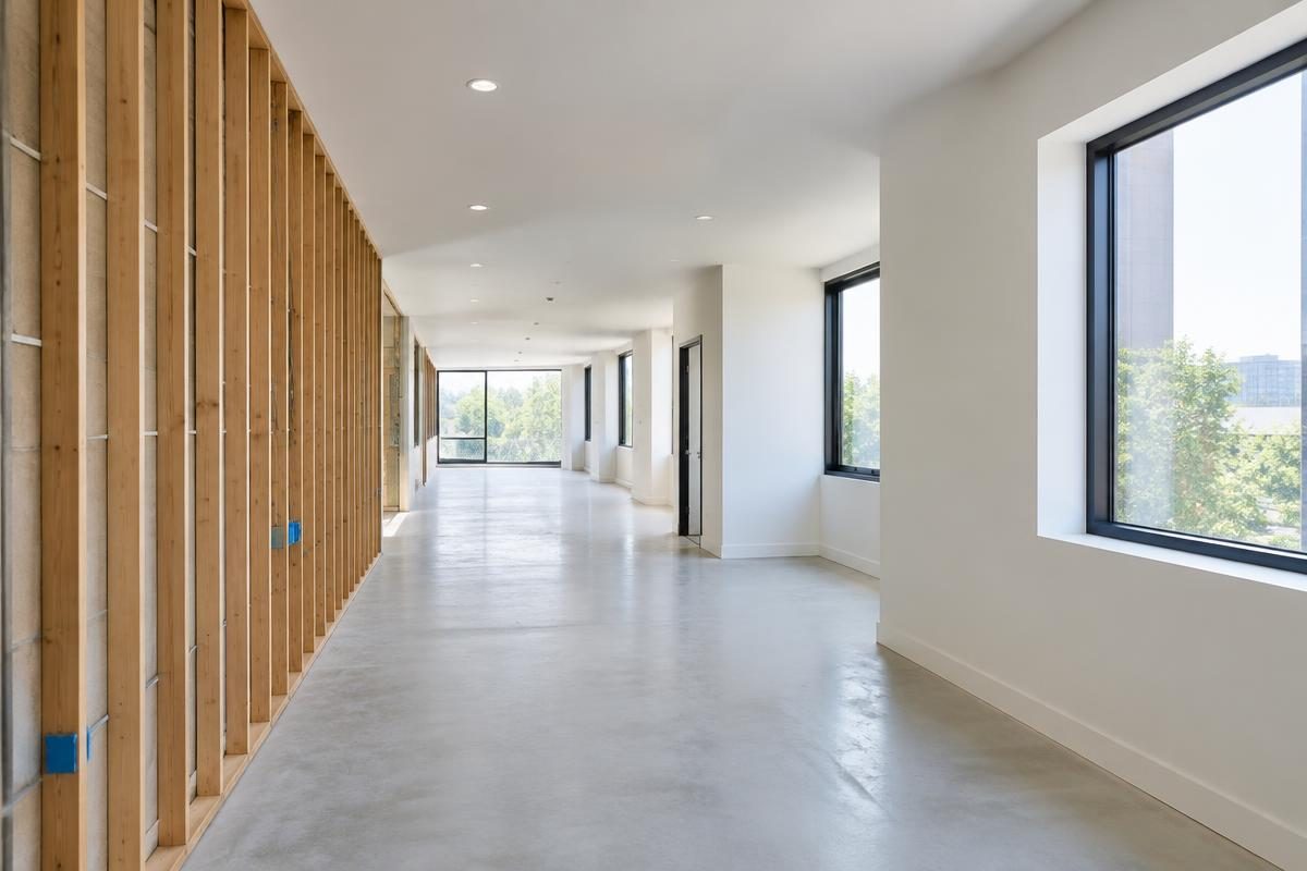 Concept commercial renovation interior with exposed framing, windows, and an open corridor